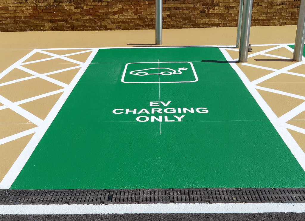 Charger space floor graphic in white on a bright green colour-block background. 